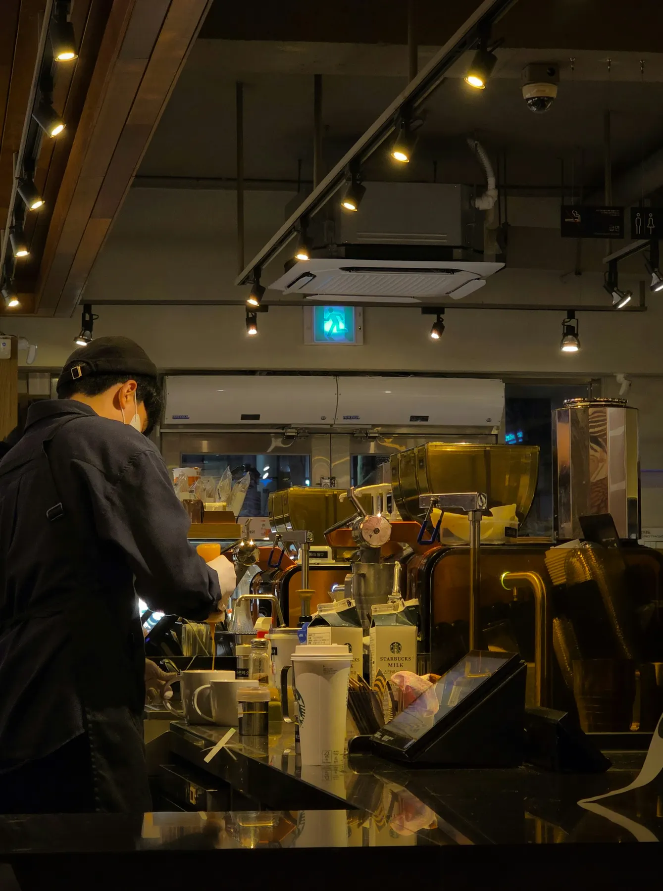 Barista working behind a warmly lit coffee bar